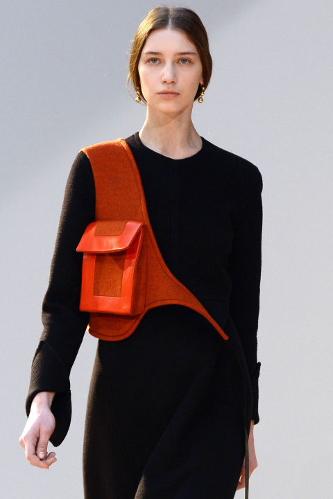 Phoebe Philo continues to innovate in the accessory arena, this season introducing the holster handbag in an orange shade—the ultimate "hands-free" bag.