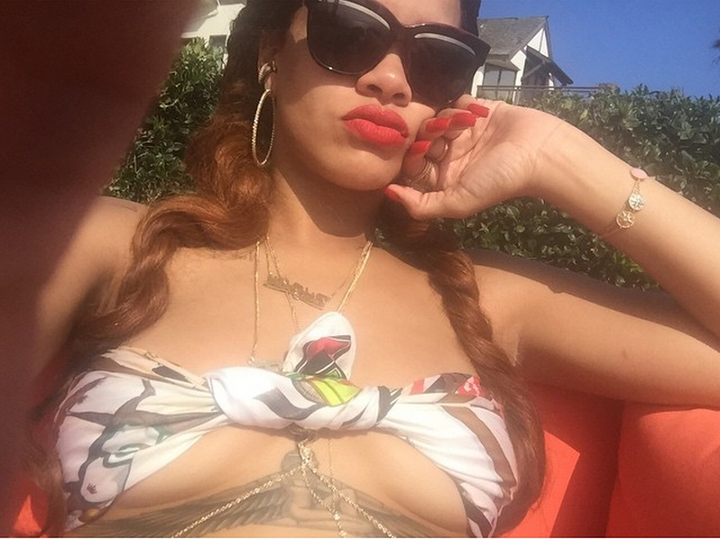 Rihanna discovers a new way to wear an Hermes scarf—as a bikini top—in a poolside selfie posted to Instagram.
