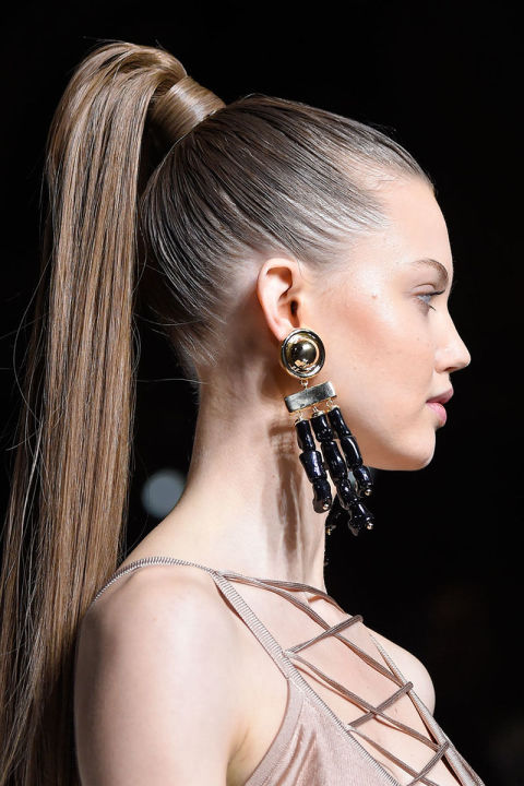 The Look: Warrior Princess
How-To: It used to be that when you thought of Balmain, you thought of Kim Kardashian. Now, it's Gigi and Kendall and all the other bright young things in fashion's coolest girl gang, but the sex! sex! sex! quality remains. The Balmain girl, as the adage goes, is the one you want to be and your boyfriend wants to date. (Which is to say, a little too unreal.) Boldness and strength not only ruled this season's collection—after all, Rousteing is 30 this year and at the top of the game—but the beauty look, too, which featured "exaggeratedly high sex ponytails" (thanks to lots of silky, tapered extensions) by Sam McKnight and "naturally tanned, caramel-toned skin that feels like a sunset" by Tom Pecheux. To pull off the bronze sculpting without falling into Youtube Contouring 101 territory, Pecheux spends his time blending until he can't blend any more, and then blending some more. He starts with a brown cream, which he swipes across the lids and rubs in all the way up the hollows of the cheekbones, then switches to a shimmery bronzer and blends that from the apples to the temples, mixing it in with the cream. A few taps of highlighter go under the eyes and across the brow bones and, voila!, a look that says, according to Pecheux, "it's always summer here."
Backstage Essentials: M.A.C. Cream Colour Base Pro Palette in Mid-Tone Sepia, $14, maccosmetics.com; Balmain Clip Tape Extensions, $74, balmainhair.com.