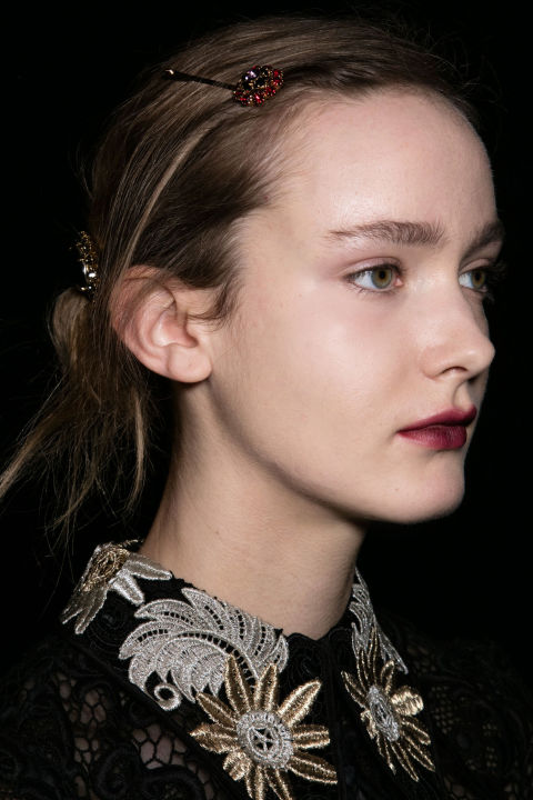 For a modern nod to the '30s, Anthony Turner pulled the hair into a low ponytail, rolled it in toward the nape of the neck and held it in place with jeweled bobby pins, while Val Garland painted on Black Dahlia-inspired lips using NARS Velvet Matte Lip Pencil in Train Bleu and Mysterious Red.<br />