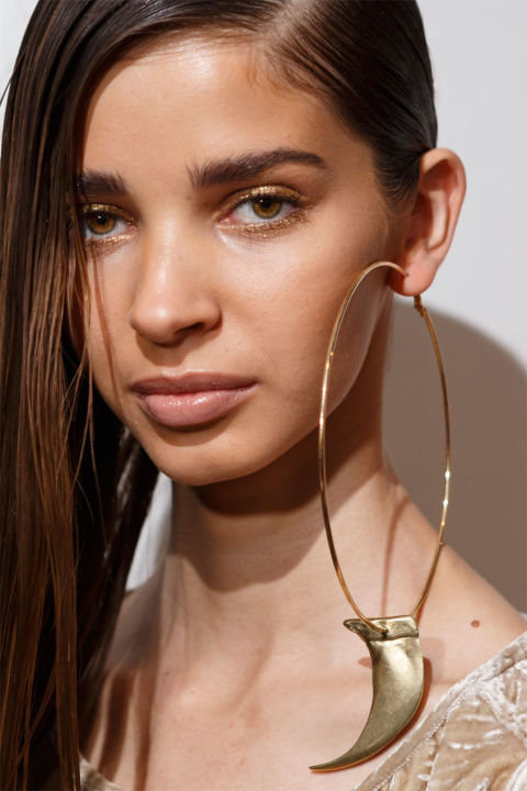 Sleek hair and gold glitter eyes were just as cool as the oversize hoop earrings at Nicholas K. Backstage, makeup artist Sarah Lucero used the Stila Glitter &amp; Glow Liquid Eye Shadow in Golden Goddess to line both the upper and lower lashline. A little contouring enhanced the overall&nbsp;warm glow of the look, and Lucero finished with a swipe of Stila Apricot Lip Glaze, a pinky-nude shade with a slick finish.